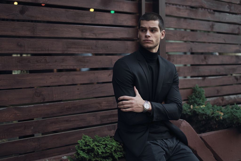 fashionable-man-wearing-suit-sitting-against-wooden-wall (1).jpg